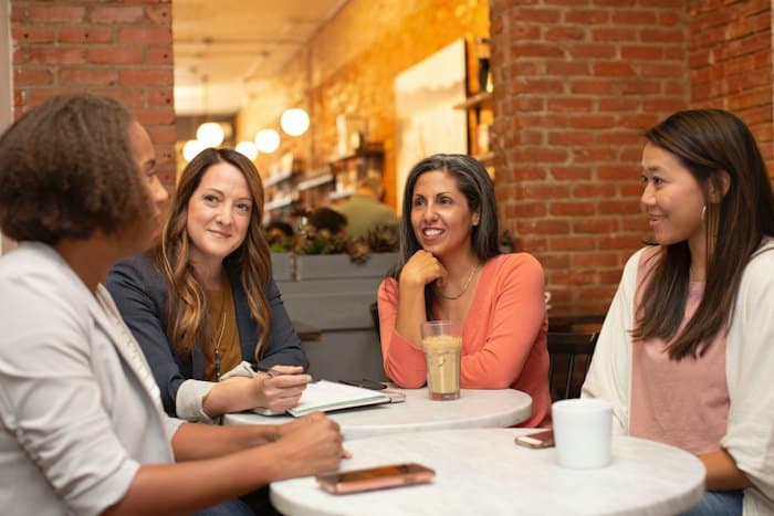 Equipe de mulheres conversando em uma reunião num café